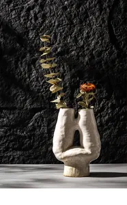 Artistic white ceramic vase with textured surface and unique asymmetrical H-shape design.