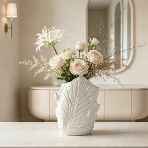 Detailed macro shot of white ceramic vase featuring intricate leaf vein texture design