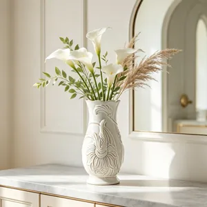 Vintage French white ceramic vase with relief floral patterns holding calla lilies