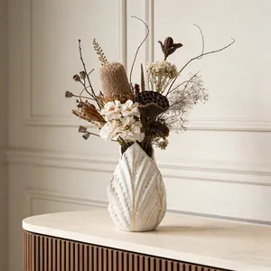 Vista dettagliata del vaso in ceramica bianco crema con trama a foglia e fiori