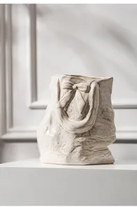 Detail shot of a French romantic ceramic bag-shaped vase with a textured bow design
