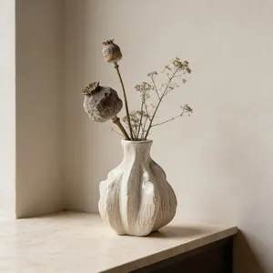 Artistic macro view of white ceramic vase with organic wavy texture and dried poppy pods