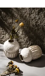 Detailed close-up of Wabi-sabi style white ceramic vases with a rough handmade texture.