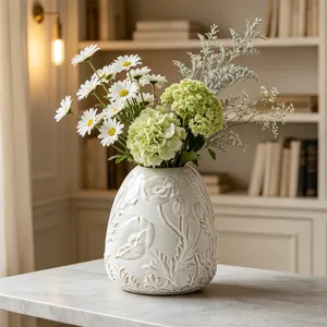 Detailed view of a cream-colored ceramic vase featuring intricate vintage floral relief patterns