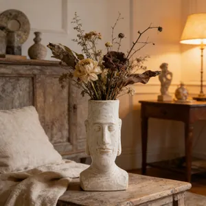 Vista dettagliata di un vaso in ceramica Moai vintage con fiori secchi su un tavolo