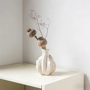Close-up of white ceramic vase with unique wavy texture and organic bulb shape.