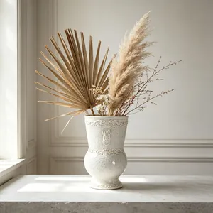 Close-up of elegant French vintage embossed white ceramic vase filled with pampas grass decor.