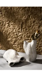 Detailansicht von handgefertigten strukturierten Keramik-Wabi-Sabi-Vasen vor einer rustikalen Wand
