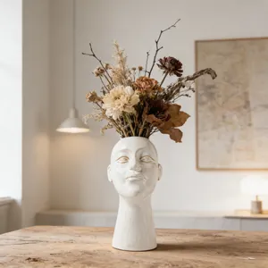 Artistic ceramic human face vase with textured glaze detail in a warm home setting