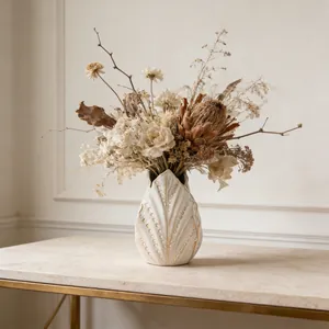 Vaso artistico in ceramica bianca con bouquet di fiori secchi su tavolo di marmo