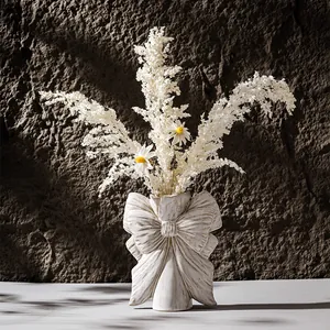 Elegant bow-shaped white ceramic vase with dried flower arrangement for home decor