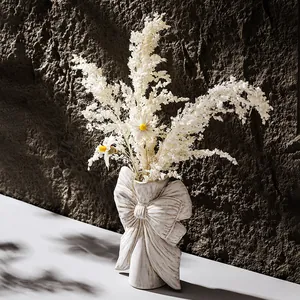 Elegant white ceramic vase with large bow design for dried flowers and home decor