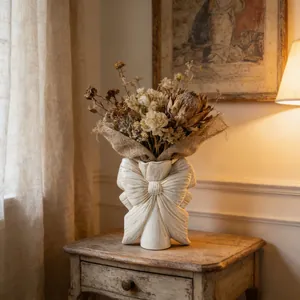 Élégant vase en céramique nœud blanc crème avec fleurs séchées dans un intérieur vintage