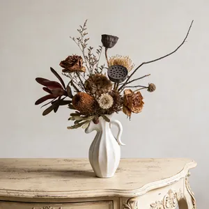 Vintage crème keramische vaas met droogbloemstuk op een houten tafel in huis