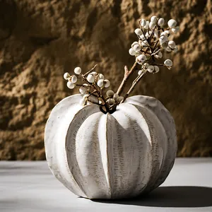 Artistic textured white ceramic pumpkin-shaped vase with dried berries for elegant home decor