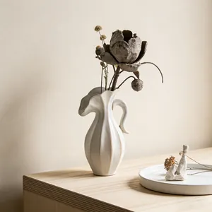 Elegante witte Scandinavische keramische bloemenvaas met gegolfde rand en handvat