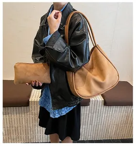 Détail du grand sac cabas en daim avec pochette assortie porté par un mannequin