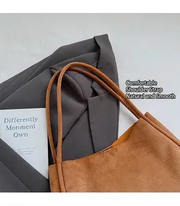 Gros plan d'un sac cabas en daim marron avec des bretelles lisses et texture élégante.