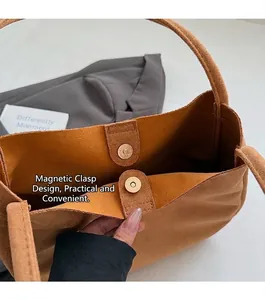 Vue détaillée du fermoir magnétique d'un sac à bandoulière en daim marron de qualité