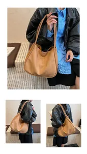 Grand sac fourre-tout en faux daim porté par un mannequin comme sac d'épaule.