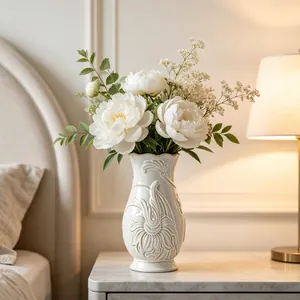 Detailed close-up view of a cream ceramic vase with intricate relief floral carving