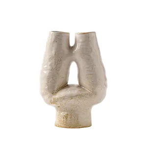 Modern abstract ceramic vase with unique U-shape in creamy white finish