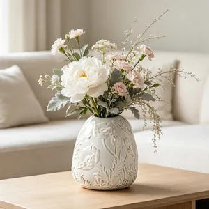 Detailed view of vintage cream ceramic vase featuring exquisite embossed floral patterns