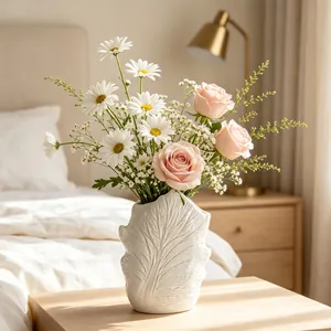 White minimalist ceramic flower vase featuring unique leaf vein texture in a bedroom setting.