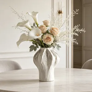 Artistic white ceramic vase featuring a unique ribbed texture with an elegant floral arrangement