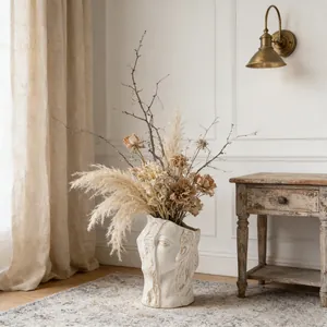 Modern abstract face ceramic vase arrangement with dried pampas grass in a cozy Nordic room