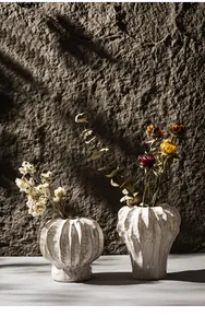 Detailed view of white textured ceramic vases showcasing artistic wabi-sabi glaze and shadows