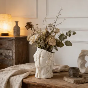 Creative abstract face ceramic vase holding dried flowers for rustic home decor setup