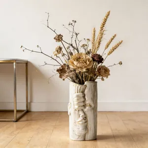 Vista dettagliata del vaso in ceramica bianca con rilievo creativo del viso umano