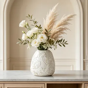 Detailed view of cream ceramic vase with embossed floral pattern and flowers