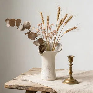 Vaso in ceramica color crema stile francese con rilievi floreali e bordo ondulato, rustico.