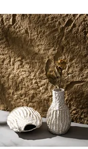 Detailed view of white textured ceramic vase featuring a rustic rock-like surface finish
