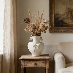 Shabby chic heart-shaped ceramic vase with bow relief detail on a vintage wooden table
