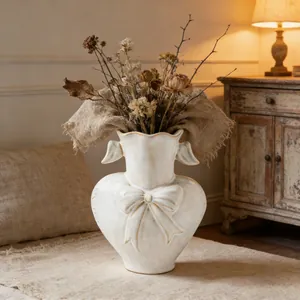 Vintage white ceramic vase with relief bow detail and distressed finish for home decor