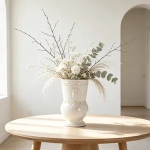 French vintage white embossed ceramic vase with bunny detail displayed on a wooden table