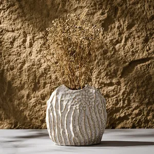 Elegant vintage textured white ceramic vase with dried flowers for modern home decor.