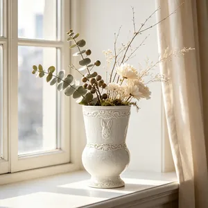 Vintage French style white ceramic vase with rabbit relief and elegant flower arrangement.