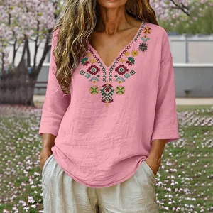 Detail view of pink cotton linen blouse featuring vintage heavy embroidery and V-neckline.