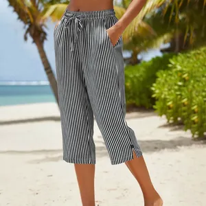 Detailed view of striped summer pants with drawstring and side slits at the beach