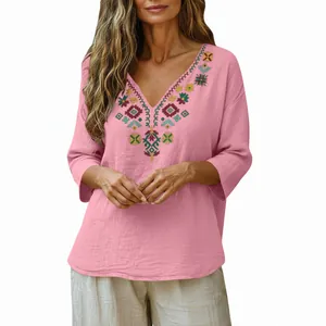 Detail view of a vintage pink cotton linen blouse featuring ethnic embroidery and a V-neckline