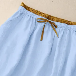 Detailed macro view of contrast yellow drawstring waistband on light blue linen skirt