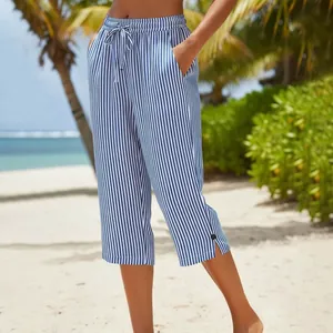 Detail of summer blue striped cropped pants with drawstring waist and side button slit.