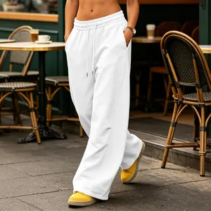 Close-up of white wide-leg sweatpants with drawstring waist in a street cafe setting