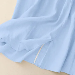 Close-up detail of light blue cotton linen maxi skirt fabric showing natural texture