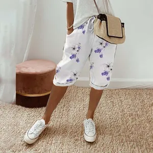 Women's casual white cotton linen shorts with purple floral print and drawstring waist.