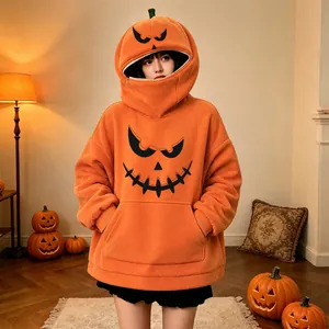 Dettaglio di una felpa oversize arancione con una faccia da zucca per Halloween